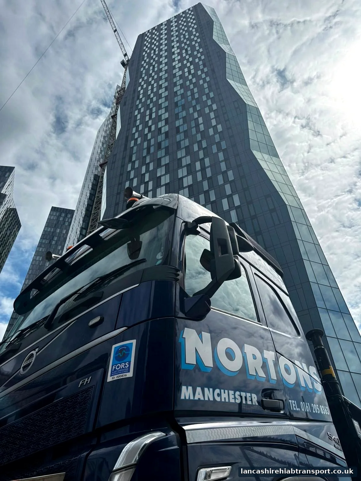 Hiab crane working beside a Manchester city-centre high-rise