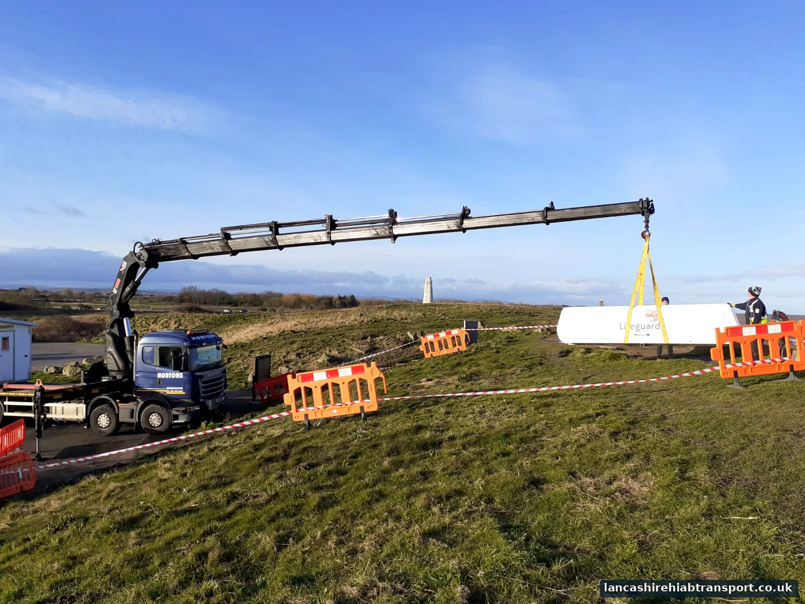 Long-reach Hiab crane lifting a portable cabin