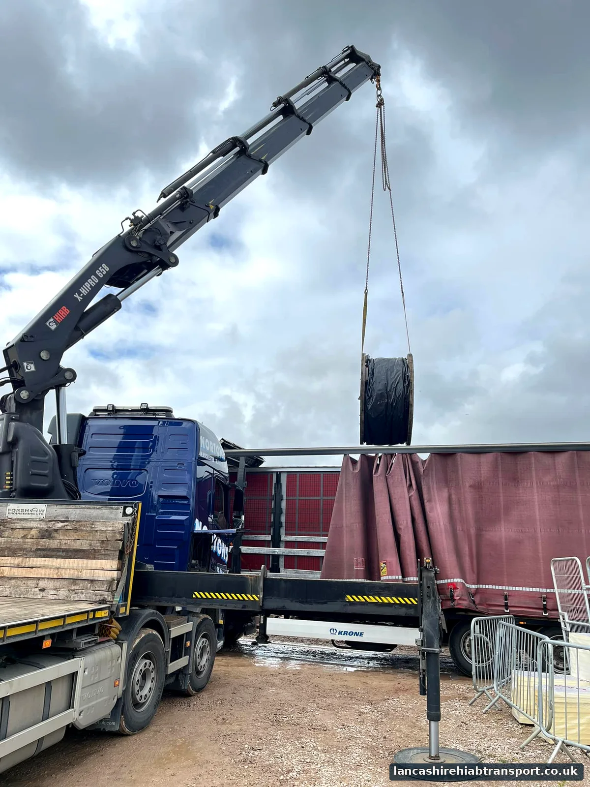 Lorry-mounted crane lifting industrial equipment