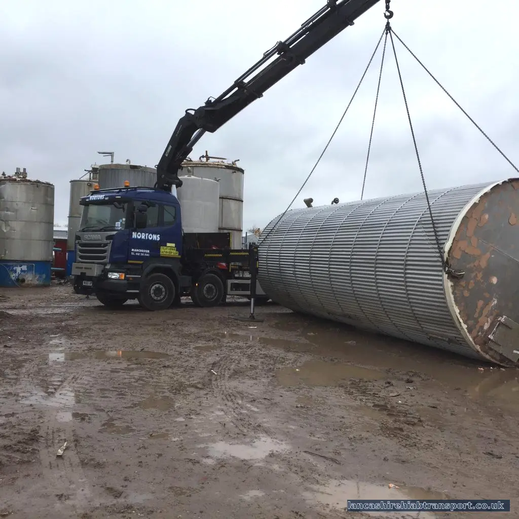 Operated Hiab crane lorry lifting a large industrial tank