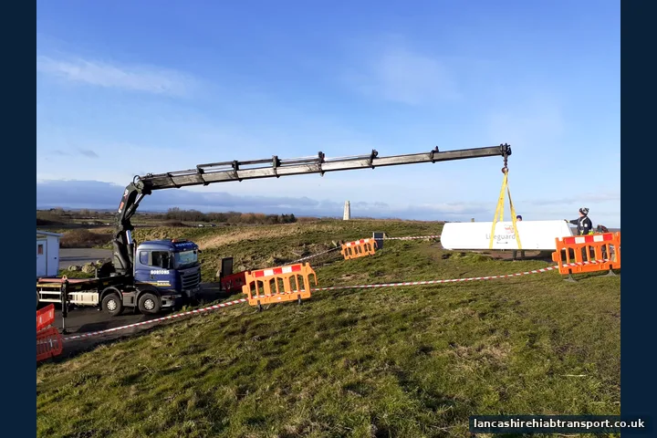 Long-reach Hiab crane lifting a portable cabin