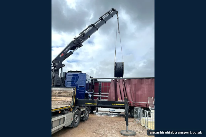 Lorry-mounted crane lifting industrial equipment