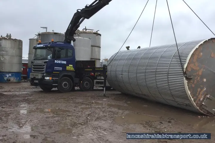 Operated Hiab crane lorry lifting a large industrial tank